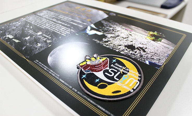 Patch for use only by team members of the SLIM project affixed to the certificate of gratitude from JAXA